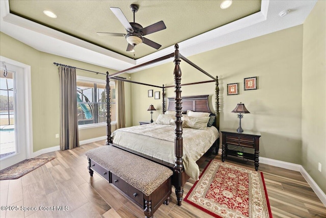 4464 Preservation Cir, Melbourne, FL 32934 - bedroom featuring a tray ceiling, wood finished floors, recessed lighting, and ceiling fan
