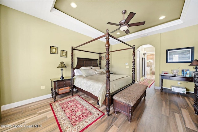 4464 Preservation Cir, Melbourne, FL 32934 - bedroom featuring arched walkways, a raised ceiling, wood finished floors, recessed lighting, and ornamental molding