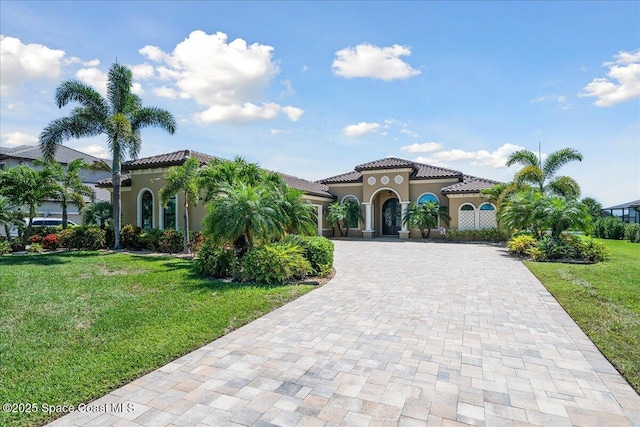 4464 Preservation Cir, Melbourne, FL 32934 - mediterranean / spanish home with decorative driveway, stucco siding, a tiled roof, and a front lawn