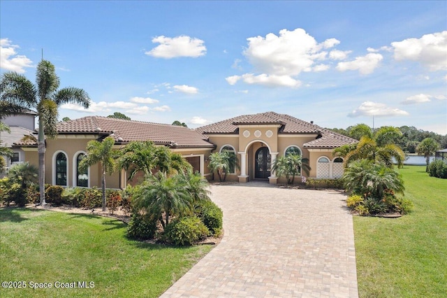 4464 Preservation Cir, Melbourne, FL 32934 - mediterranean / spanish-style home featuring an attached garage, decorative driveway, stucco siding, and a front lawn