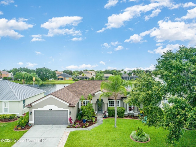 4185 Fenrose Cir, Melbourne, FL 32940 - view of front of property with stucco siding, an attached garage, a front yard, driveway, and a water view
