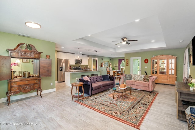 950 Douglas St SE, Palm Bay, FL 32909 - living room with a raised ceiling, recessed lighting, a ceiling fan, and light wood-style floors