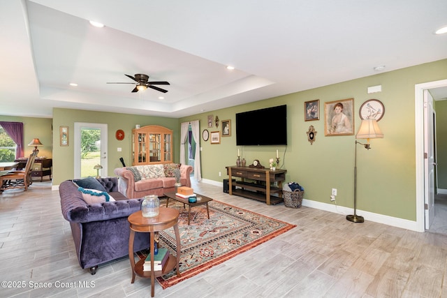 950 Douglas St SE, Palm Bay, FL 32909 - living area featuring a tray ceiling, recessed lighting, light wood finished floors, and a ceiling fan