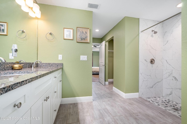950 Douglas St SE, Palm Bay, FL 32909 - bathroom featuring vanity, a tile shower, recessed lighting, and wood finished floors