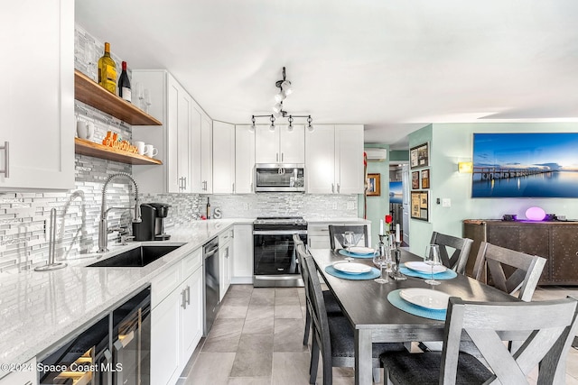 116 San Paulo Cir Unit 16-116, West Melbourne, FL 32904 - kitchen featuring appliances with stainless steel finishes, open shelves, backsplash, and white cabinetry