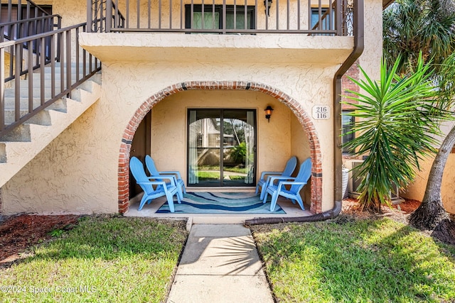 116 San Paulo Cir Unit 16-116, West Melbourne, FL 32904 - doorway to property featuring a balcony and stucco siding