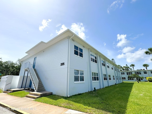 225 Buccaneer Ave Unit C2-207, Merritt Island, FL 32952 - view of home's exterior with stairway and a lawn