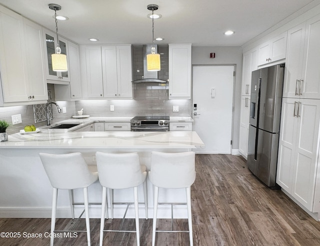 225 Buccaneer Ave Unit C2-207, Merritt Island, FL 32952 - kitchen with stainless steel appliances, wall chimney exhaust hood, a peninsula, white cabinetry, and recessed lighting