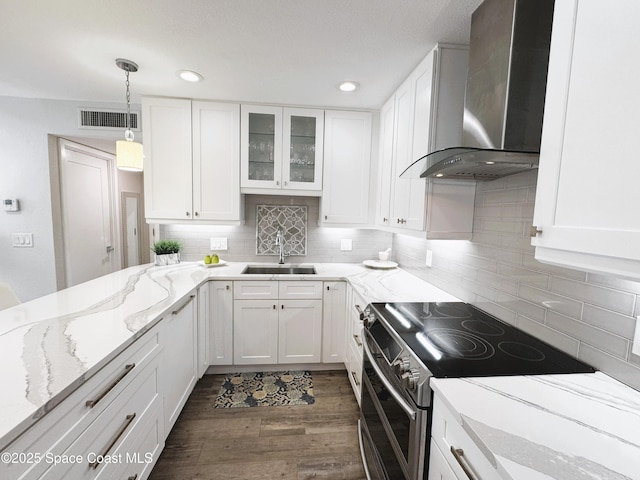 225 Buccaneer Ave Unit C2-207, Merritt Island, FL 32952 - kitchen with stainless steel range with electric cooktop, wall chimney exhaust hood, white cabinets, tasteful backsplash, and recessed lighting