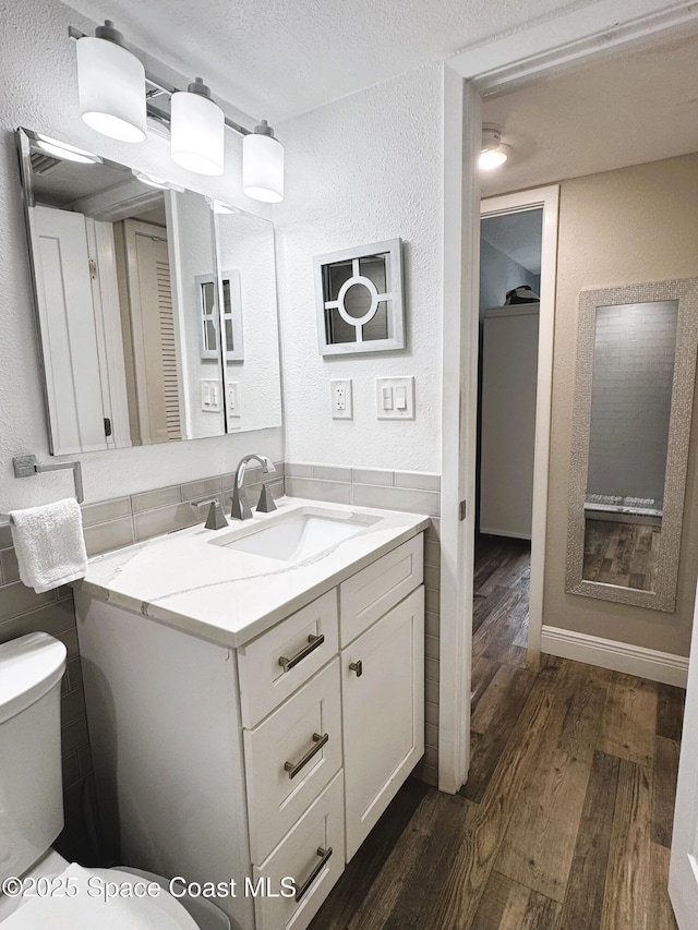 225 Buccaneer Ave Unit C2-207, Merritt Island, FL 32952 - bathroom featuring a textured wall, wood finished floors, vanity, and a textured ceiling