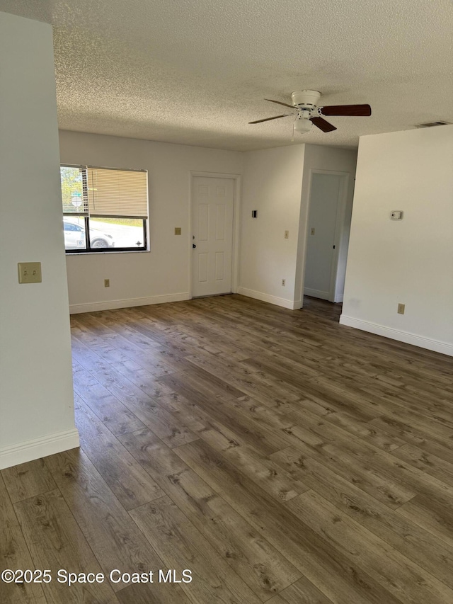 1112 Wabash Rd SE, Palm Bay, FL 32909 - unfurnished living room featuring a textured ceiling, a ceiling fan, and dark wood-type flooring