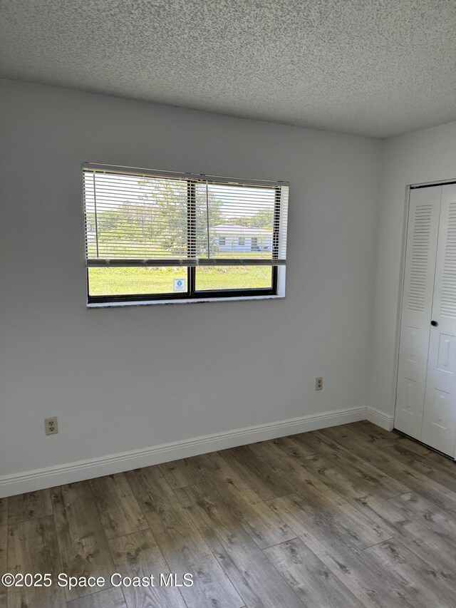 1112 Wabash Rd SE, Palm Bay, FL 32909 - unfurnished bedroom featuring wood finished floors, a textured ceiling, and a closet