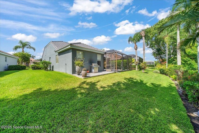 984 Wimbledon Dr, Melbourne, FL 32940 - back of property with a patio area, stucco siding, a lawn, and glass enclosure