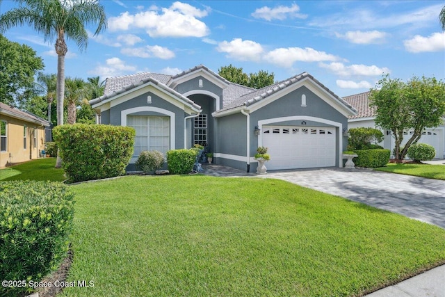 984 Wimbledon Dr, Melbourne, FL 32940 - ranch-style home with stucco siding, a garage, a front yard, a tile roof, and decorative driveway
