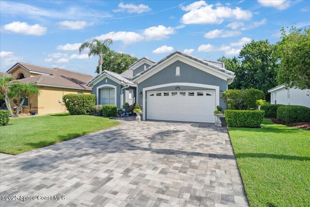 984 Wimbledon Dr, Melbourne, FL 32940 - view of front facade with an attached garage, stucco siding, decorative driveway, a front lawn, and a tile roof