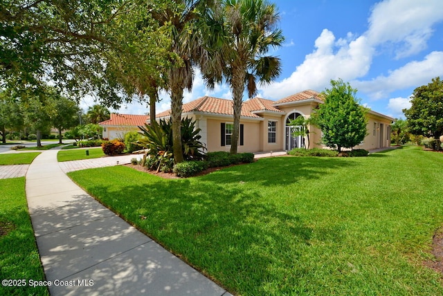3531 Plume Way SE, Palm Bay, FL 32909 - mediterranean / spanish-style home with a tiled roof, stucco siding, and a front yard