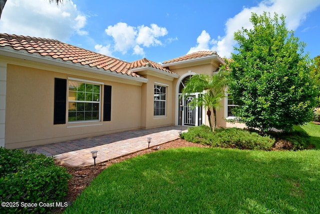 3531 Plume Way SE, Palm Bay, FL 32909 - doorway to property with a yard, a tile roof, and stucco siding