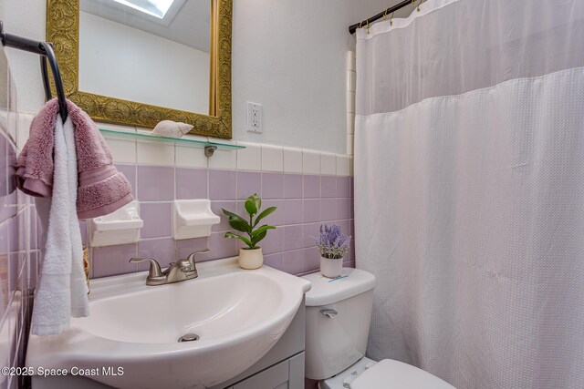 936 Santa Cruz Rd, Cocoa Beach, FL 32931 - full bathroom featuring vanity, a skylight, a shower with shower curtain, and a wainscoted wall