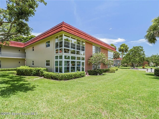 26 Pine Arbor Ln Unit 205, Vero Beach, FL 32962 - back of house featuring a lawn and stucco siding
