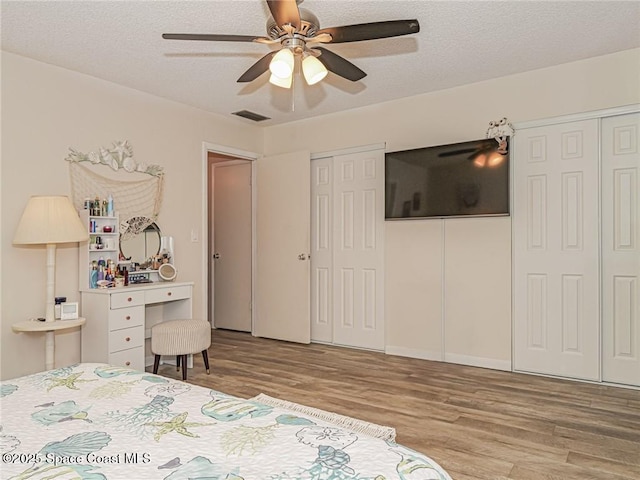 26 Pine Arbor Ln Unit 205, Vero Beach, FL 32962 - bedroom featuring wood finished floors, multiple closets, a textured ceiling, and a ceiling fan
