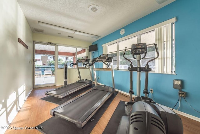 26 Pine Arbor Ln Unit 205, Vero Beach, FL 32962 - workout area featuring a textured ceiling, plenty of natural light, and wood finished floors