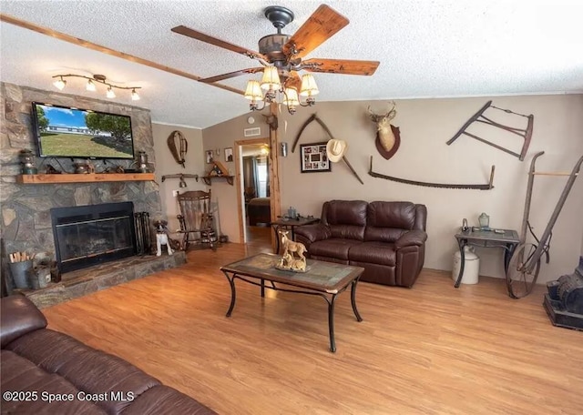 1317 Ashlee Ct, Auburndale, FL 33823 - living room featuring a ceiling fan, a textured ceiling, wood finished floors, and a stone fireplace