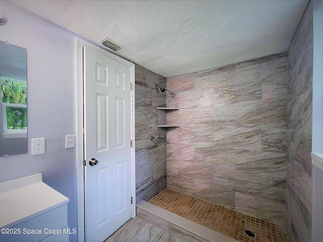 2309 Dairy Rd, Melbourne, FL 32904 - full bath with tiled shower, vanity, marble look tile flooring, and a textured ceiling