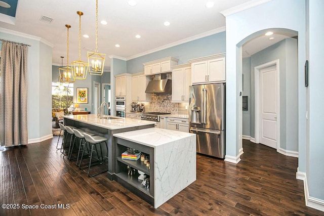 7354 Lucaya Ct, Melbourne, FL 32940 - kitchen with stainless steel appliances, exhaust hood, an island with sink, arched walkways, and recessed lighting
