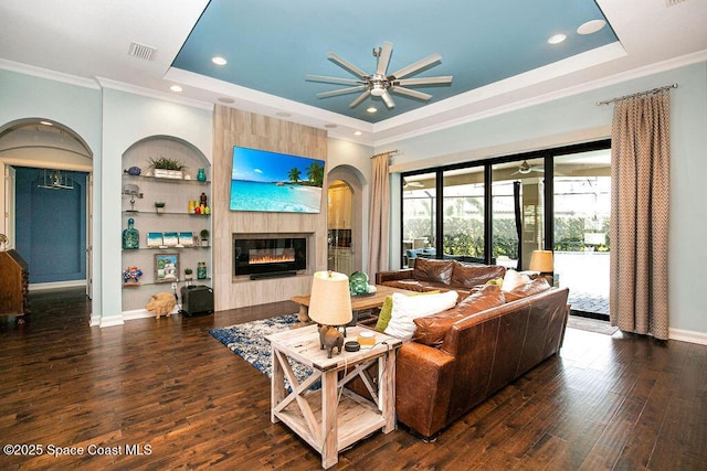 7354 Lucaya Ct, Melbourne, FL 32940 - living area with a tray ceiling, ceiling fan, crown molding, wood finished floors, and a fireplace