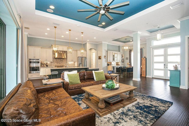 7354 Lucaya Ct, Melbourne, FL 32940 - living area featuring a ceiling fan, a tray ceiling, ornamental molding, dark wood finished floors, and french doors