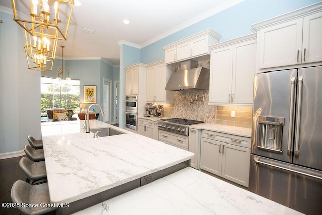 7354 Lucaya Ct, Melbourne, FL 32940 - kitchen with appliances with stainless steel finishes, a chandelier, wall chimney range hood, backsplash, and ornamental molding