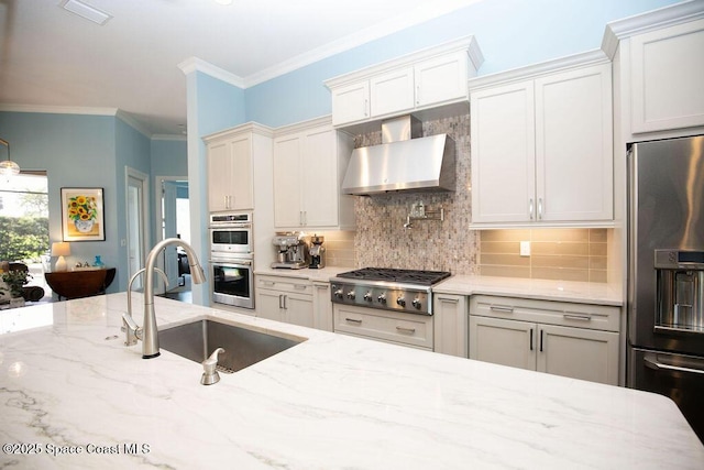 7354 Lucaya Ct, Melbourne, FL 32940 - kitchen featuring appliances with stainless steel finishes, wall chimney exhaust hood, decorative backsplash, light stone countertops, and ornamental molding