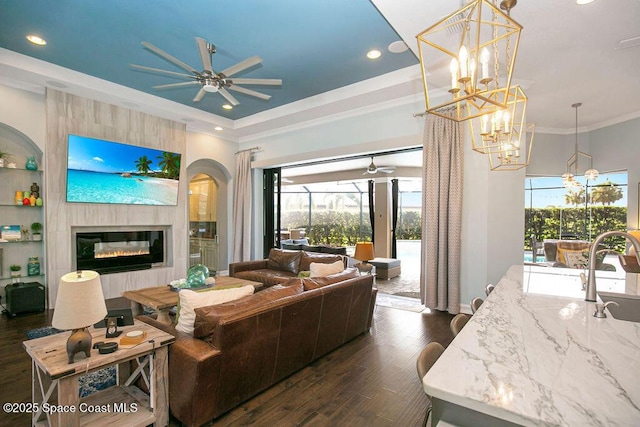 7354 Lucaya Ct, Melbourne, FL 32940 - living room with a ceiling fan, dark wood finished floors, a glass covered fireplace, ornamental molding, and recessed lighting