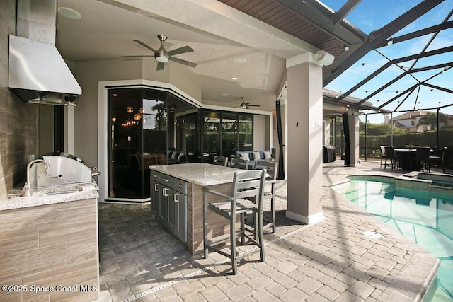 7354 Lucaya Ct, Melbourne, FL 32940 - view of patio / terrace featuring exterior kitchen, ceiling fan, a pool with connected hot tub, and a lanai
