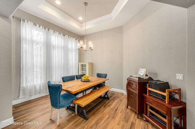 4554 Preservation Cir, Melbourne, FL 32934 - dining space with a chandelier, light wood-type flooring, a raised ceiling, recessed lighting, and crown molding