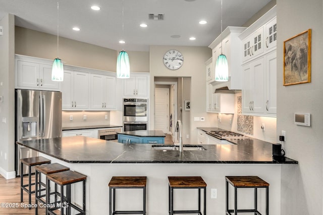 4554 Preservation Cir, Melbourne, FL 32934 - kitchen featuring stainless steel appliances, recessed lighting, decorative backsplash, a breakfast bar, and white cabinets