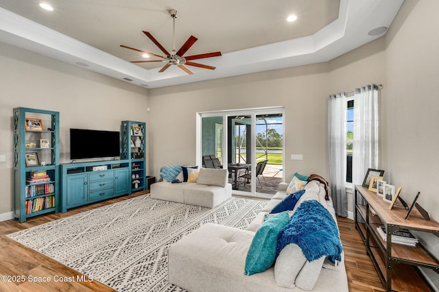 4554 Preservation Cir, Melbourne, FL 32934 - living room with wood finished floors, a tray ceiling, a ceiling fan, and recessed lighting