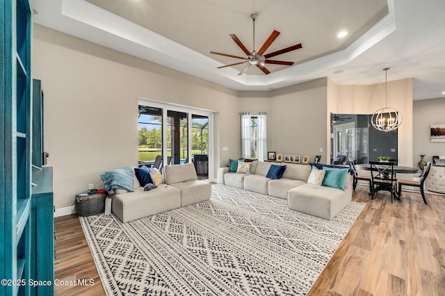 4554 Preservation Cir, Melbourne, FL 32934 - living area with a raised ceiling, ceiling fan, a chandelier, wood finished floors, and recessed lighting