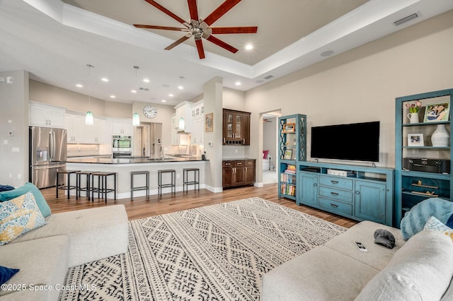4554 Preservation Cir, Melbourne, FL 32934 - living area featuring a ceiling fan, a tray ceiling, light wood-type flooring, recessed lighting, and ornamental molding
