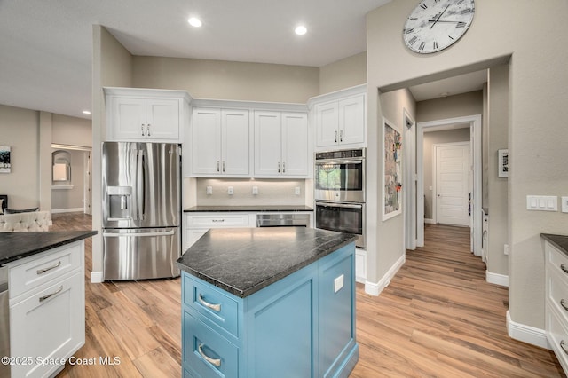 4554 Preservation Cir, Melbourne, FL 32934 - kitchen featuring stainless steel appliances, blue cabinets, white cabinets, light wood-style flooring, and recessed lighting