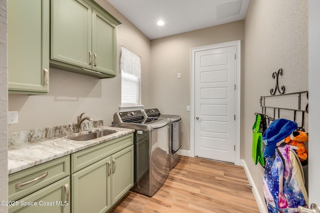 4554 Preservation Cir, Melbourne, FL 32934 - kitchen with green cabinets, washing machine and dryer, light wood-style floors, light stone countertops, and recessed lighting