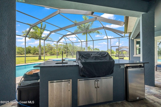 4554 Preservation Cir, Melbourne, FL 32934 - view of patio / terrace featuring exterior kitchen, an outdoor pool, glass enclosure, and view of wooded area