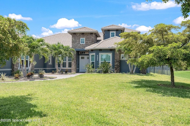 4554 Preservation Cir, Melbourne, FL 32934 - view of front of property featuring stucco siding, a tile roof, and stone siding