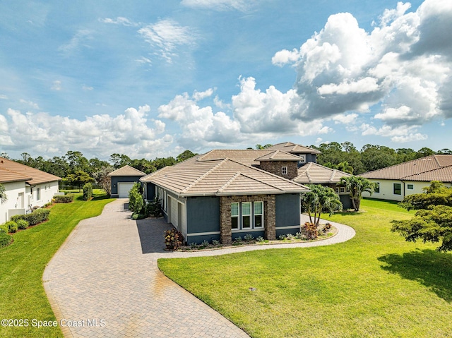4554 Preservation Cir, Melbourne, FL 32934 - view of front facade with a tile roof, a front lawn, a detached garage, and stucco siding