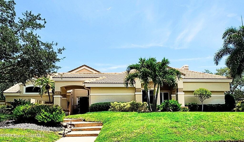 3067 Rio Palma N, Indialantic, FL 32903 - mediterranean / spanish house with stucco siding, a front yard, and a tiled roof