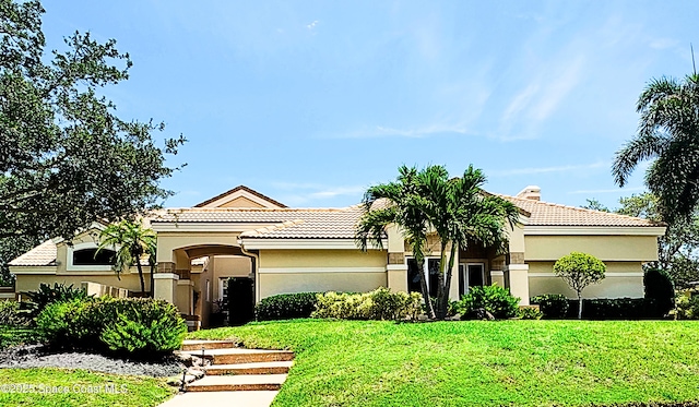 3067 Rio Palma N, Indialantic, FL 32903 - mediterranean / spanish house with stucco siding, a front yard, and a tiled roof