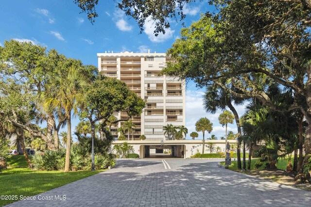 750 N Atlantic Ave Unit 203, Cocoa Beach, FL 32931 - view of property featuring a carport and decorative driveway