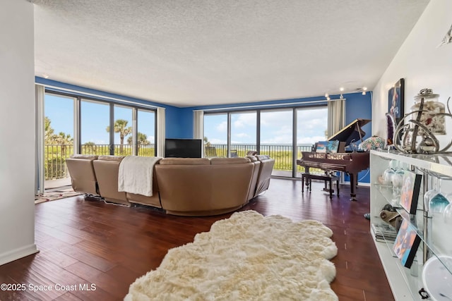 750 N Atlantic Ave Unit 203, Cocoa Beach, FL 32931 - living area featuring plenty of natural light, a textured ceiling, and hardwood / wood-style floors