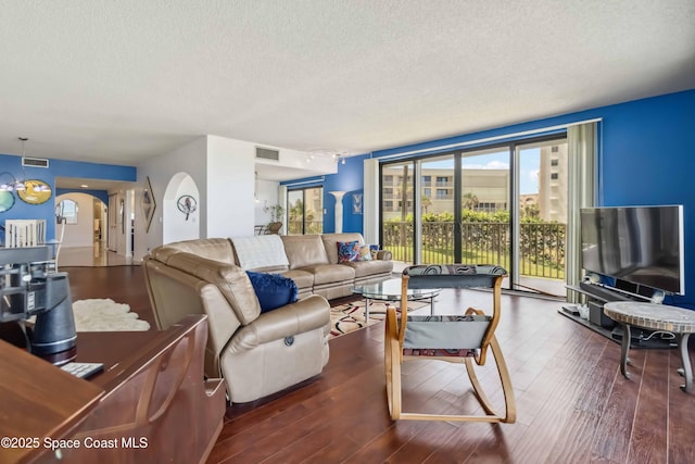 750 N Atlantic Ave Unit 203, Cocoa Beach, FL 32931 - living room featuring a textured ceiling, wood finished floors, plenty of natural light, and arched walkways