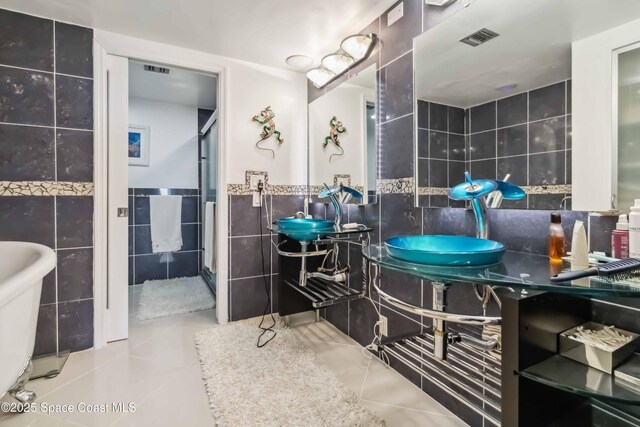 750 N Atlantic Ave Unit 203, Cocoa Beach, FL 32931 - full bath with tile walls, tile patterned floors, and wainscoting